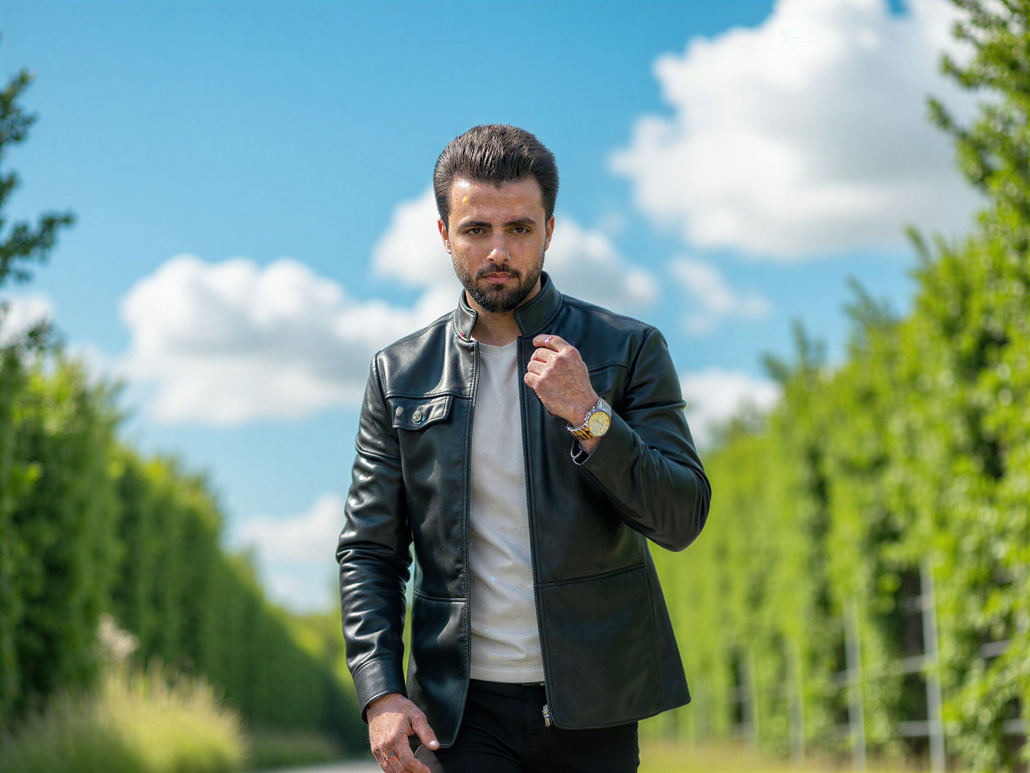 A 32-year-old male character, OD62S, embodying the essence of Mikasa Ackerman from Attack on Titan, is depicted in a hyper-realistic style. He wears a meticulously crafted replica of Mikasa's iconic military uniform, complete with a fitted dark jacket, white blouse, and black trousers. The texture of the fabric is rendered stunningly, showcasing every detail of the construct. He stands in a vibrant outdoor setting, surrounded by lush greenery under a clear blue sky, radiating an unexpected happiness that contrasts with the character's usual stoicism. The sunlight highlights his strong features and confident stance, capturing a moment of joyful determination. His expression is warm and approachable, adding depth to the portrayal while keeping true to the intricate character nuances. The lighting creates an inviting atmosphere, enhancing the mood of happiness and victory.