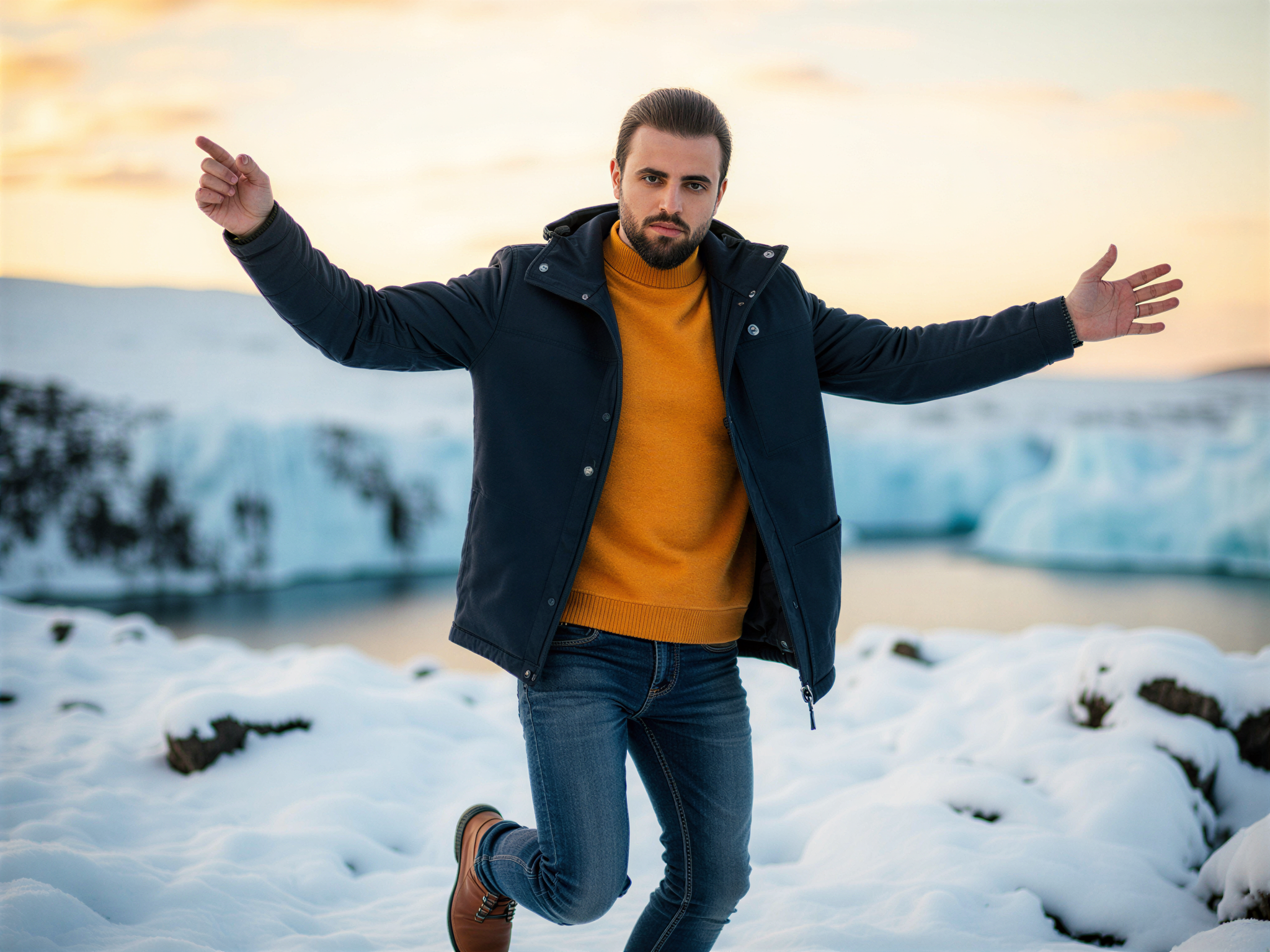 A joyful male figure, OD62S, aged 32, standing triumphantly in a breathtaking Icelandic landscape. He wears a stylish, weather-resistant jacket in a deep navy hue layered over a bright, contrasting thermal sweater. His rugged jeans complement the ensemble while snow-dusted hiking boots anchor him to the pristine, icy terrain. The backdrop features majestic glaciers and soft, swirling snowflakes falling gently around him, creating an atmosphere of winter wonder. The golden hour sunlight casts a warm, ethereal glow across the scene, enhancing the mood of happiness and adventure. His expression radiates sheer delight as he takes in the enchanting beauty of the wild, breathtaking Icelandic scenery, inviting the viewer to share in the moment.