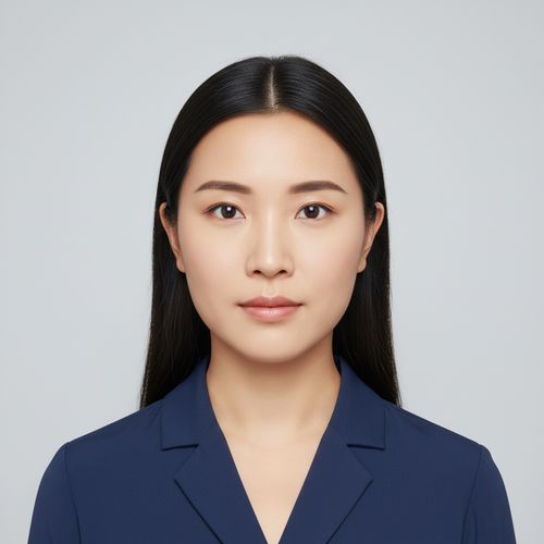 Professional portrait of a woman with long black hair, wearing a dark blue blazer, against a neutral background.