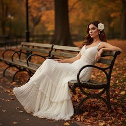Olivia, a sophisticated 32-year-old Arab woman, is immersed in the serenity of Central Park during autumn. She wears a flowing ivory chiffon georgette gown with hand-pleated cascades, a subtle sweetheart neckline, and delicate lace accents. The golden hour casts a warm glow, highlighting her graceful silhouette as she reclines on a vintage wrought-iron bench, surrounded by autumn leaves in crimson, amber, and ochre. Her soft waves of hair cascade over one shoulder, adorned with a fresh gardenia, as her contemplative expression invites viewers into her serene moment of escape. The composition reflects tranquility and elegance, perfect for a visual feature in Vogue Italia. The setting embodies the nostalgic beauty of life.  
Trigger Word: Olivia